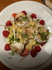 gratinierter ziegenkäse mit honig dazu himbeeren und salat mit himbeerdressing